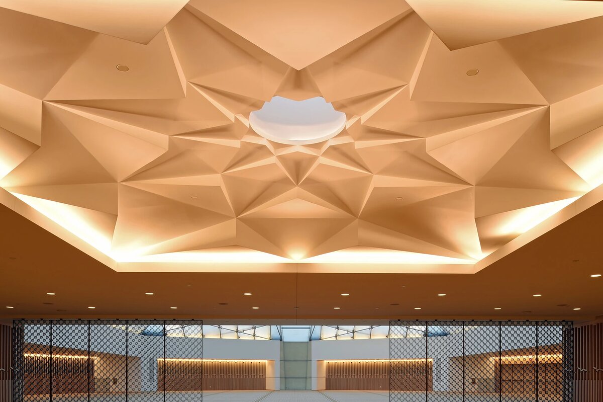 Prayer hall with muqarnas ceiling and geometric screen partition